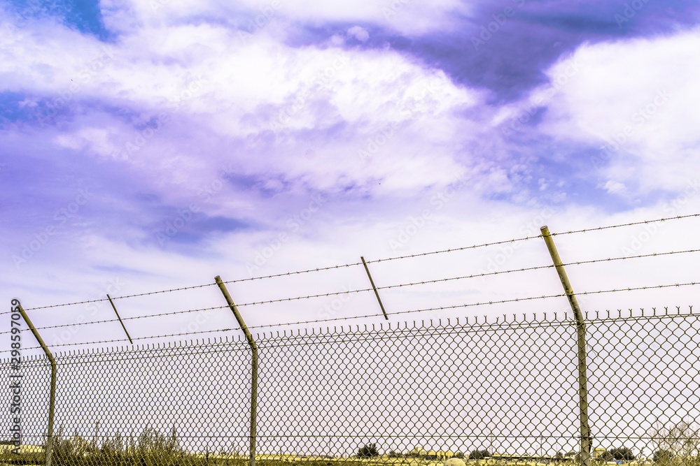 a long and strong fence of border to stop illegal migrants in the middle of desert  