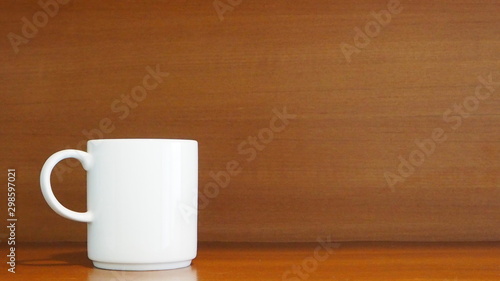 White porcelain mug on wooden shelf in the room. Living and lifestyle concept