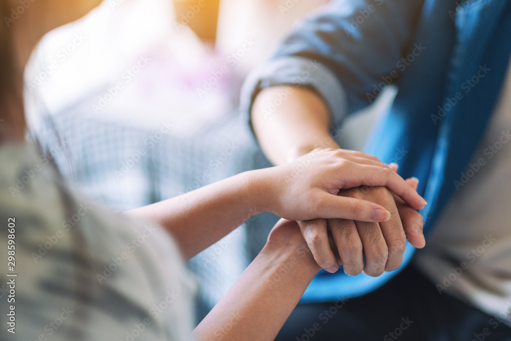 A man and a woman holding each other hands for comfort and sympathy A man and a woman holding each other hands for comfort and sympathy