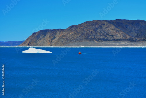 boat in the bay of the Eqip Sermia with icebergs  - melting Eqi Glacier in Greenland Disko Bay,  World of greenland travel - global warming and climate change. Summer, July © Friederike