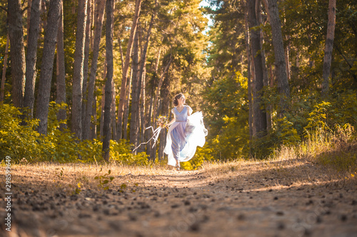 happy bride with a bouquet is walking the green park