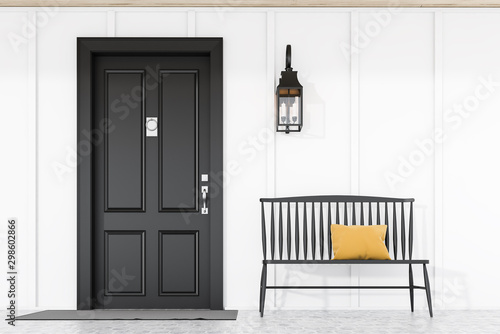 Black front door of white house with bench