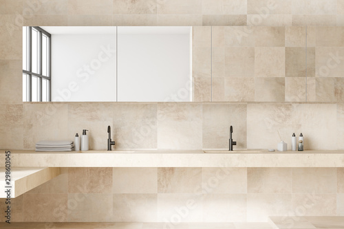 Beige tile bathroom interior with double sink