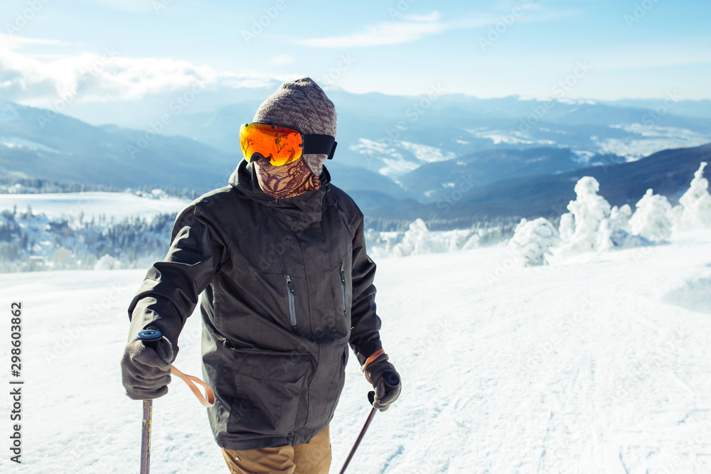 Nice young man skiing in the mountains. Skiing in the snowy mountains, Winter is coming, snowfall. Active lifestyle in winter. Ski resort season is open. Ski equipment, trail. Extreme winter sports.