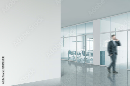 Businessman in office with mock up wall