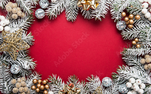 Merry Christmas and Happy Holidays greeting card, frame, banner. New Year. Noel. Silver, white and red Christmas ornaments and fir tree on red background top view. Winter holiday xmas theme. Flat lay.