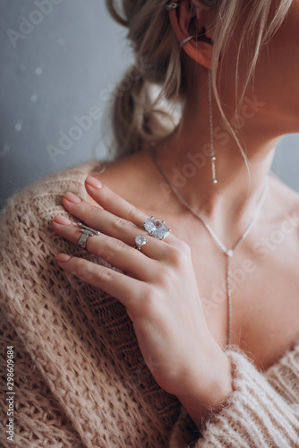 a girl in a beige jacket shows rings on her hands