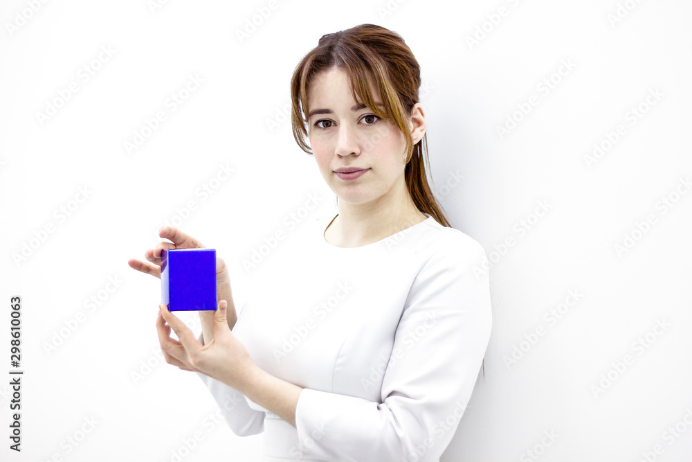 Female medical worker is demonstrating a package with cream. A woman with beauticians holds a box in her hands. Person doctor on a white wall background. Female medical worker is demonstrating a package with cream. A woman with beauticians holds a box in her hands. Person doctor on a white wall background.