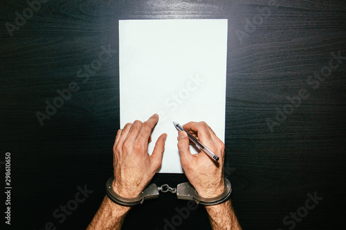 Men's hands in handcuffs. Plea agreement