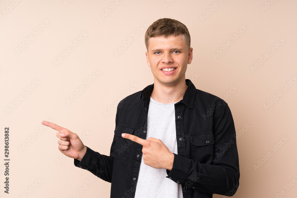 Young handsome man pointing finger to the side Young handsome man pointing finger to the side