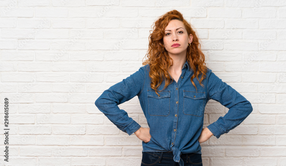 Redhead woman over white brick wall angry Redhead woman over white brick wall angry