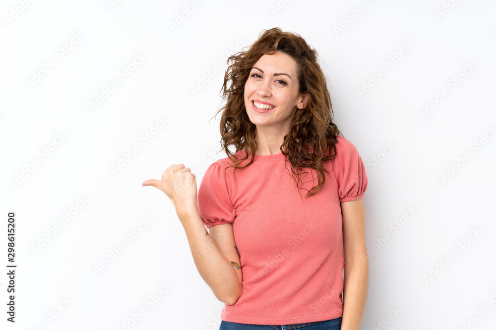 Young pretty woman over isolated background pointing to the side to present a product Young pretty woman over isolated background pointing to the side to present a product