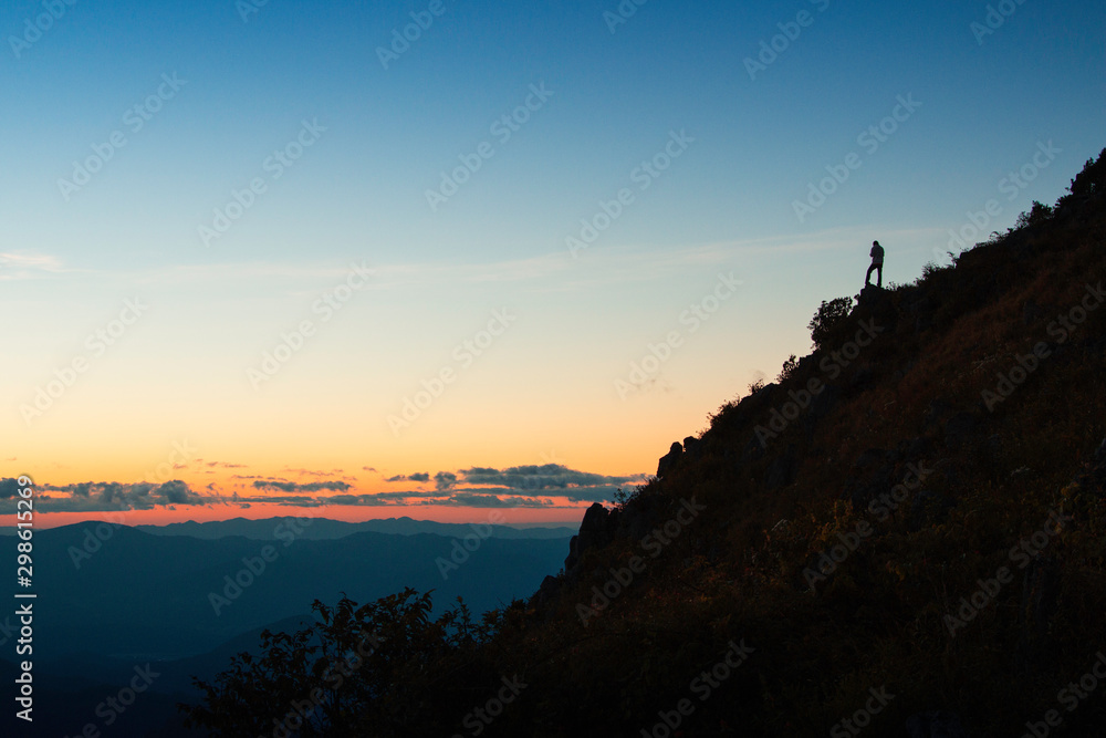 Man hikers standing on mountain cliff silhouette 