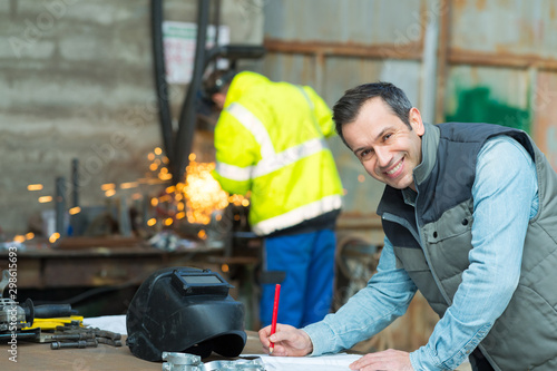 Photos happy industrial steel welder worker at factory workshop