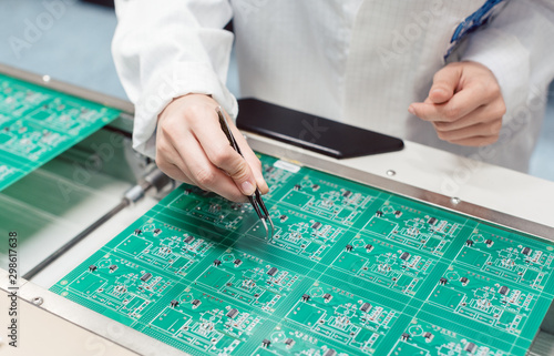 Фототапет Technician assembling electronic product by inserting components into board
