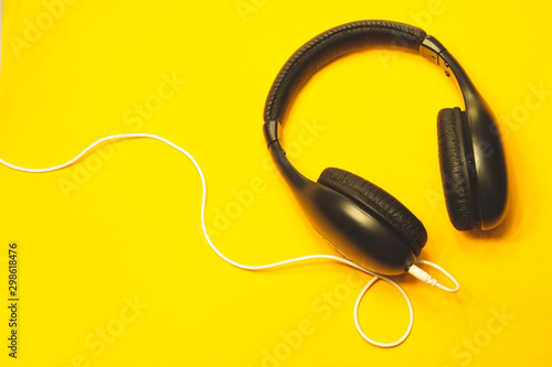 Headphones with white cable on a yellow background