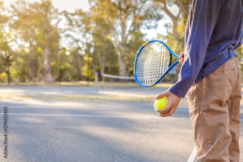 Australian boy holding tennis racket and ball at outdoor court in South  Australia © myphotobank.com.au