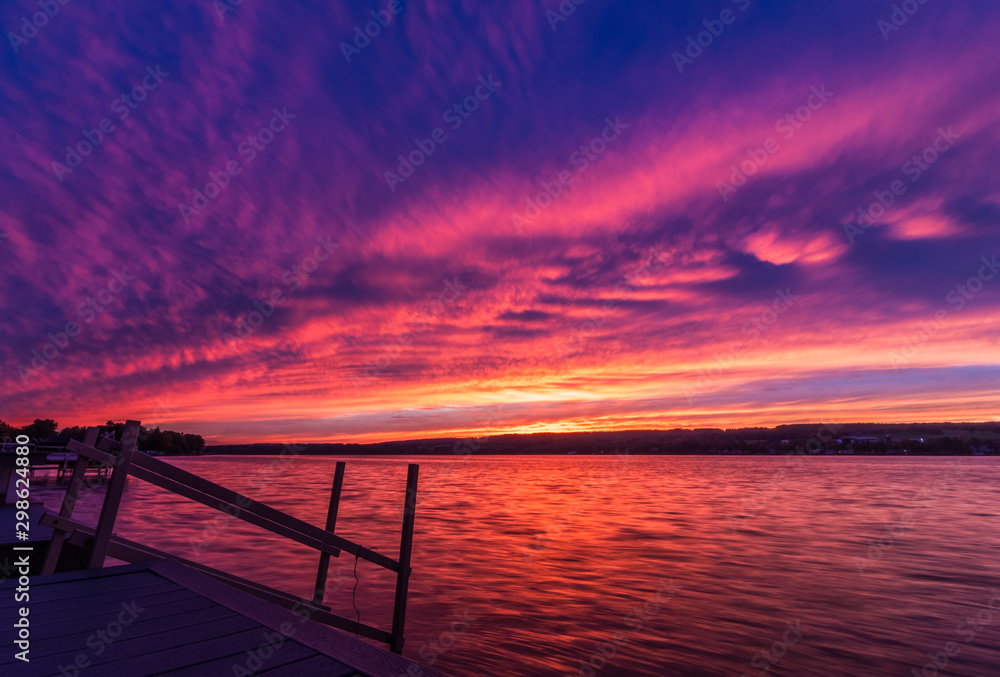 Fototapeta premium Vivid ultra violet sunset over calm water at Silver Lake, NY State