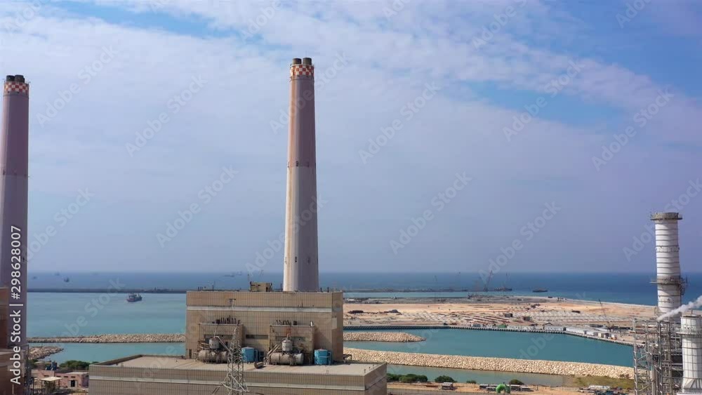 Power Plant with chimneys, Harbor and Mediterranean sea, Aerial Drone view over Power Plant with chimneys And harbor in the the background Power Plant with chimneys, Harbor and Mediterranean sea, Aerial Drone view over Power Plant with chimneys And harbor in the the background