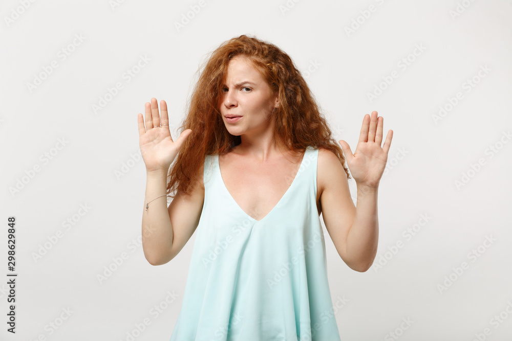 Young displeased redhead woman girl in casual light clothes posing isolated on white wall background, studio portrait. People lifestyle concept. Mock up copy space. Rising hands up, showing palms.