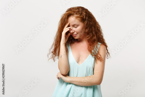 Young smiling redhead woman girl in casual light clothes posing isolated on white wall background in studio. People lifestyle concept. Mock up copy space. Keeping eyes closed, putting hand on face.