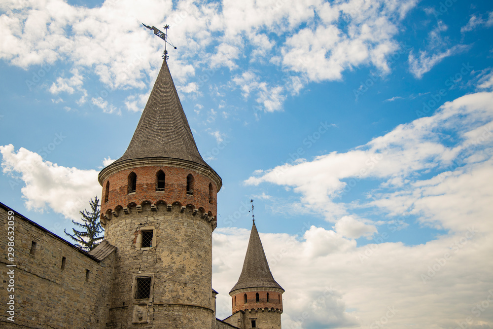 medieval castle tower old architecture fortification building sightseeing destination object from below on vivid blue sky white clouds background with empty copy space for your text medieval castle tower old architecture fortification building sightseeing destination object from below on vivid blue sky white clouds background with empty copy space for your text