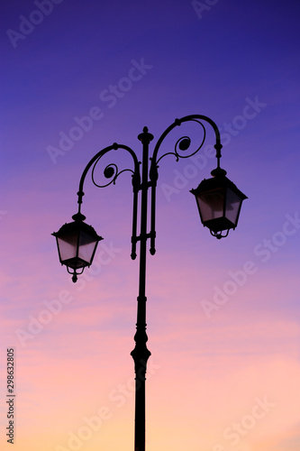 Beautiful vintage street lamp against a bright sunrise sky