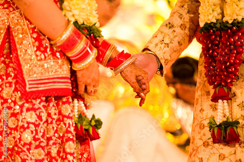 Closeup of indian wedding couple holding hands and promise to be together for lifetime.