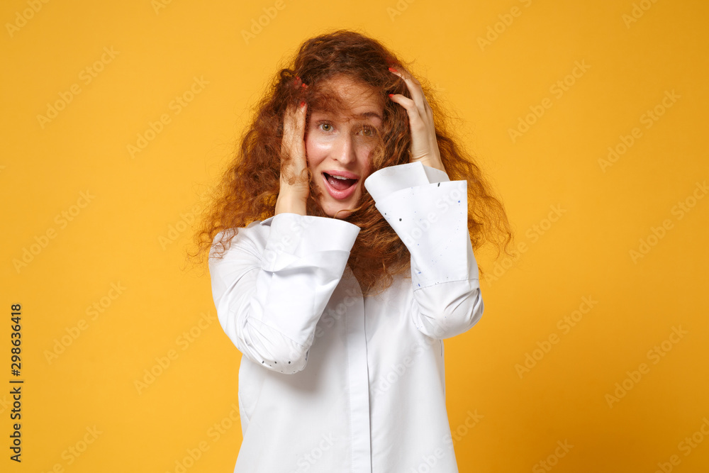 Excited young redhead woman girl in white shirt posing isolated on yellow orange wall background, studio portrait. People sincere emotions lifestyle concept. Mock up copy space. Putting hands on head. Excited young redhead woman girl in white shirt posing isolated on yellow orange wall background, studio portrait. People sincere emotions lifestyle concept. Mock up copy space. Putting hands on head.