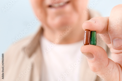 Elderly man with pills on l...