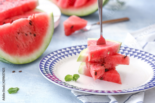 Plate with slices of ripe watermelon on table