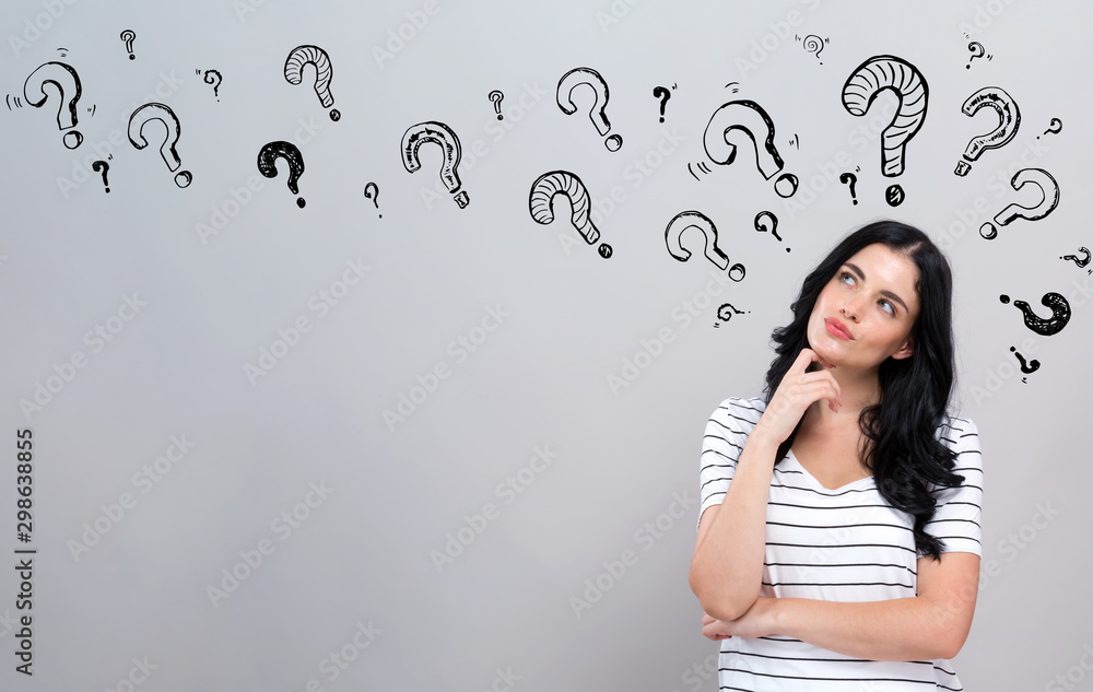 Fototapeta premium Question marks with young woman in a thoughtful face
