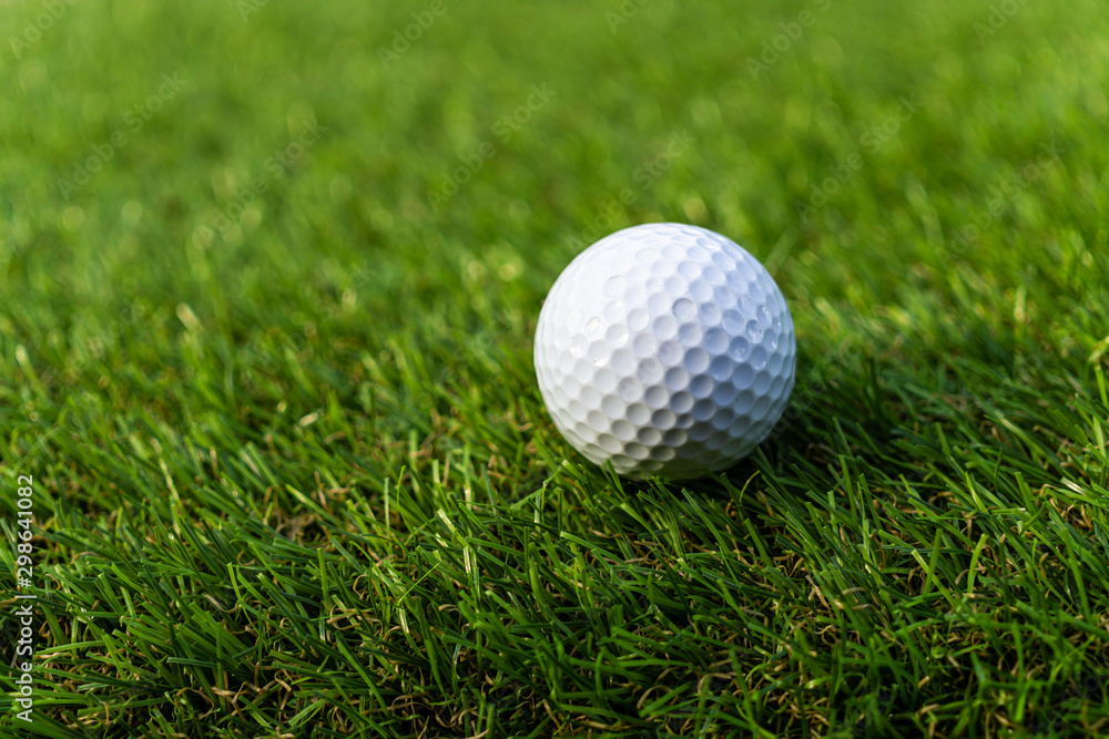 Golf ball on the green,Green grass with golf ball close-up in soft focus at sunlight. Sport playground for golf club concept - wide landscape as background for your lettering about golf playing. Golf ball on the green,Green grass with golf ball close-up in soft focus at sunlight. Sport playground for golf club concept - wide landscape as background for your lettering about golf playing.