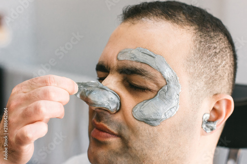 Male face waxing. Barber removes hair by shugaring from the face of turkish man.