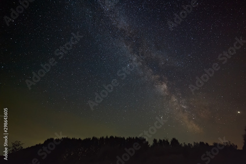 Stars of the milky way galaxy in the night sky. Space objects over the forest.