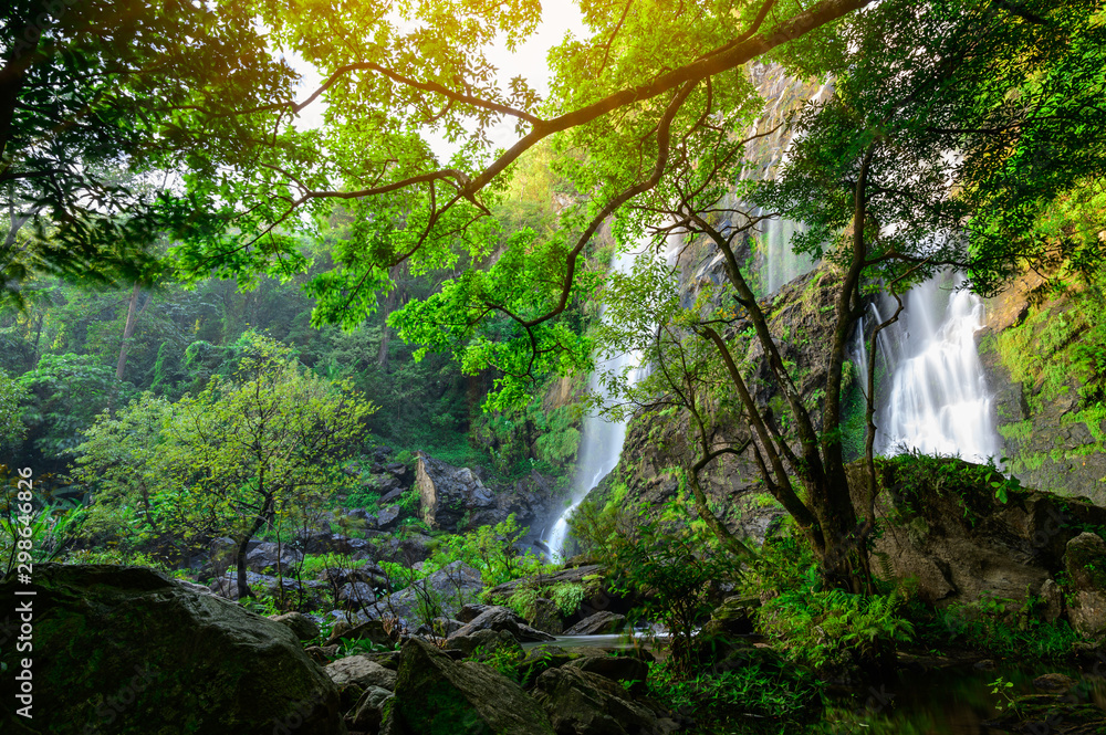 Obraz premium A beautiful waterfall deep in the tropical forest, steep mountain adventure in the rainforest.