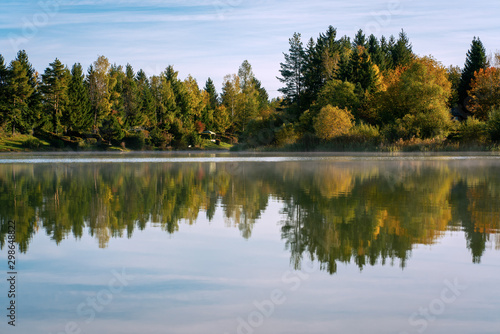 Lake Bibi (Bibisee) in Bavaria in autumn with reflexions of multi coloured trees on the water surface