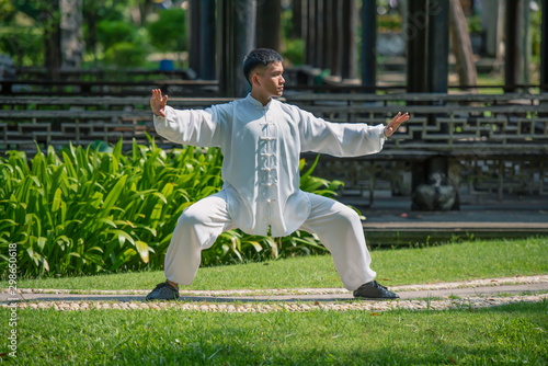 Photography Tai Chi master workout in the park.