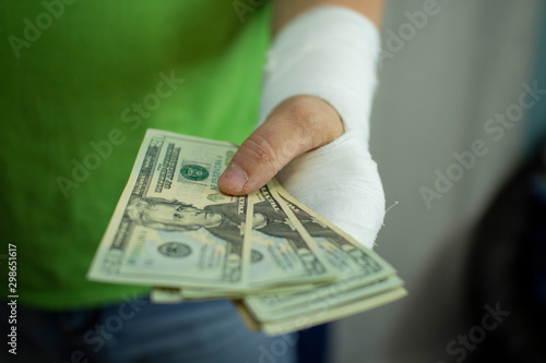 A man with an arm in a cast counted out money from the cost and expenses of emergency medical care at the hospital .