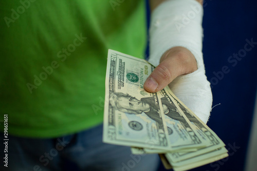 A man with an arm in a cast counted out money from the cost and expenses of emergency medical care at the hospital .