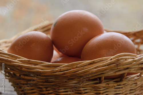 Chicken eggs lie in a wicker basket. Close-up. The light from the window. The concept is healthy, natural nutrition.