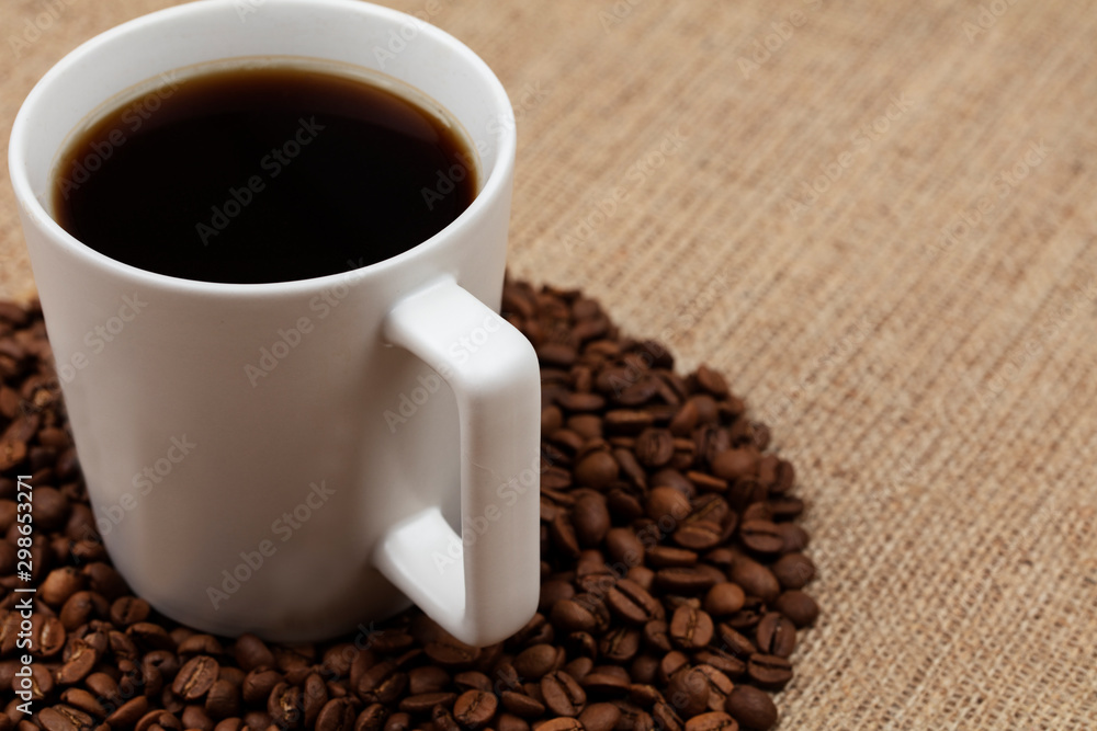 cup of coffee with beans on wooden table cup of coffee with beans on wooden table