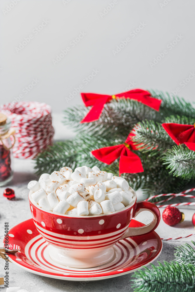 Cocoa with marshmallow in a red Cup on the table with Christmas decorations. Composition in red. The concept of Christmas cards Cocoa with marshmallow in a red Cup on the table with Christmas decorations. Composition in red. The concept of Christmas cards