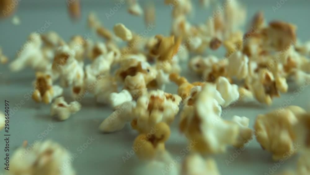 Close up popcorn falling on gray floor. Slow motion. Closeup. Fresh fluffy popcorn falling on authentic gray table. Close up popcorn falling on gray floor. Slow motion. Closeup. Fresh fluffy popcorn falling on authentic gray table.