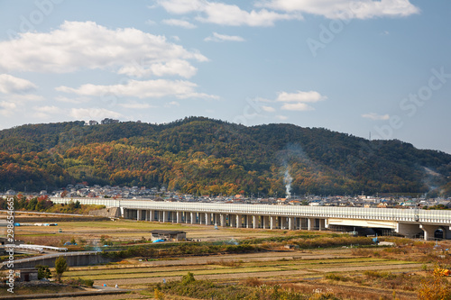View on japanese countryside with highway bridge and forested hills on background
