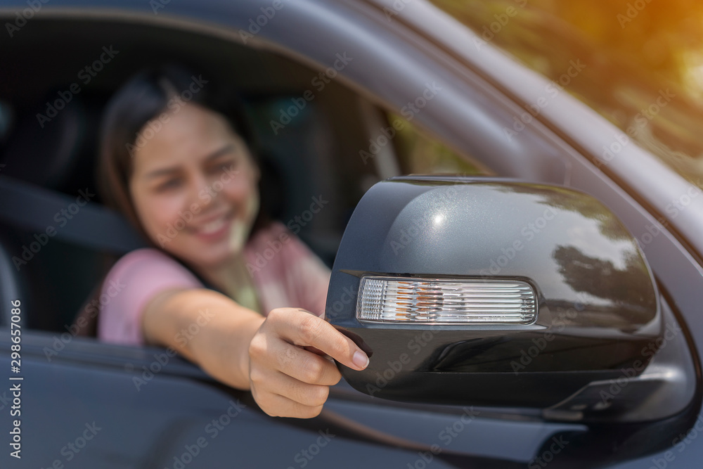 getting ready. Close up Hand of young woman gesture adjusting side rear-view mirror And using seat belts for safety while driver car during Learn to drive At a driving school by Trustworthy company