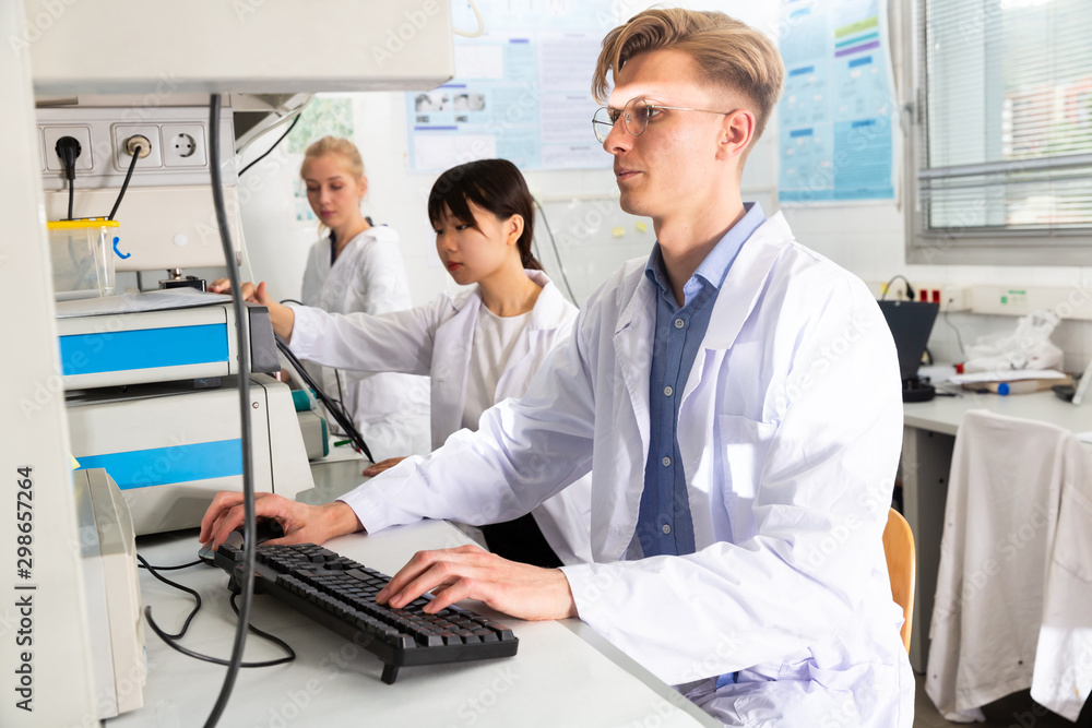 Scientists in white coats working at laboratory