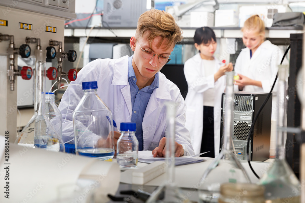 Fototapeta premium student of Faculty of Biology writing results in test chart