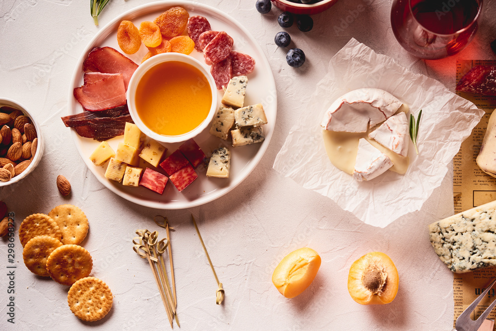 Red wine with different kinds of cheese, charcuterie assortment, crackers, grapes, nuts Red wine with different kinds of cheese, charcuterie assortment, crackers, grapes, nuts