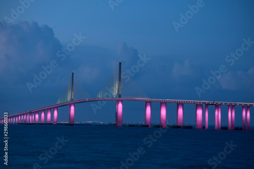The iconic Sunshine Skyway Bridge spanning the wide mouth of beautiful Tampa Bay in central Florida lit up in pink LED lights to commemorate Breast Cancer Awareness Month. photo